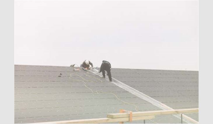 Workers try to restore the roof system by Sept. 11. 