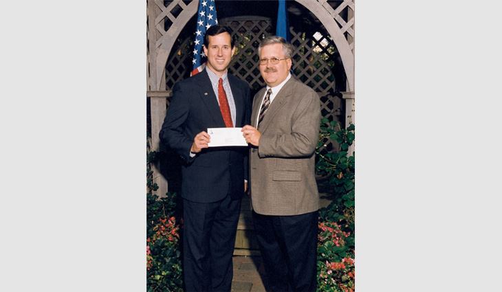 John Gooding (right) chairman of the board of Gooding, Simpson & Mackes Inc., Ephrata, Pa., presents Sen. Rick Santorum (R-Pa.) with a ROOFPAC contribution.
