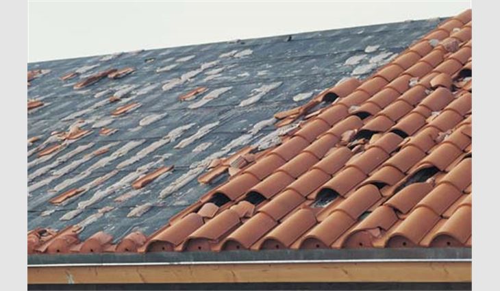 These clay tiles were mortar-set. Three failure modes are illustrated: Separation of the mortar from the cap sheet, separation of the tile from the mortar and debris impact damage. On the opposite side of this roof, a fourth failure mode occurred where the built-up membrane and tiles adhered to the membrane blew off.