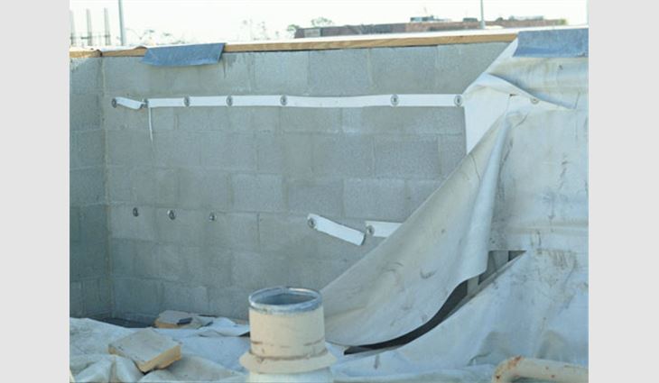 The base flashing of this mechanically attached single-ply membrane was mechanically attached to the parapet. Blow-off was initiated by lifting and peeling of the coping. However, had the coping been more securely attached, high suction forces likely would have caused the base flashing to blow off. With the new provisions in ASCE 7, wind loads on the base flashing now can be calculated so the appropriate number of fasteners can be specified.
