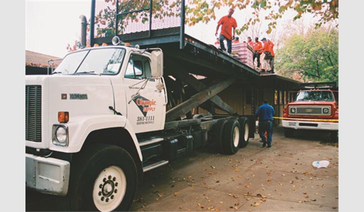 Workers from Madsen Roof Co. Inc., Sacramento, Calif., unload donated materials to reroof a children's housing unit at Sacramento Children's Home.