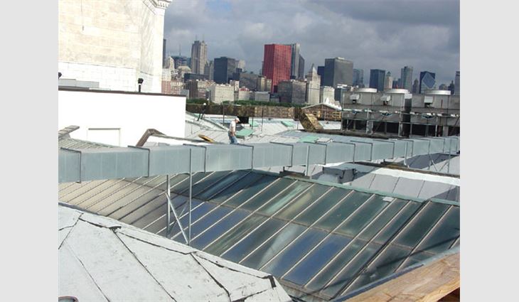 An overview of the complicated and cluttered work area on the main roof. In the background is the mechanical penthouse that received the prototype roof assembly.