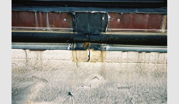 In this photo, you can see how an aged SPF base flashing has survived differential movement in the nonwall supported deck. Note the elastomeric sheets totally have parted across the deck portion of the expansion detail. The copper counterflashing has pulled apart at the joint. This 1988 SPF installation showed no distress and continues to function. This deck runs along a second-story wall that is not shown. 