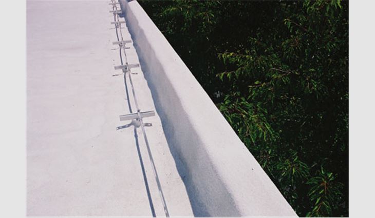 In some instances, the metal cap flashing system completely is covered by the SPF system with no loss in performance. This photo shows a low masonry parapet wall and metal cap system covered with SPF and coating along the perimeter of a 1998 installation.