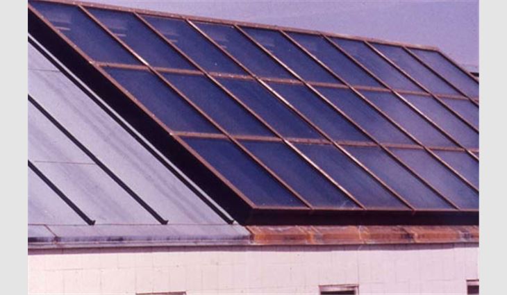 This photo shows the copper roof system with a glass and aluminum skylight on Middlebury Elementary School, Middlebury, Conn. Note the corrosion is confined to the copper flashing under the skylight.