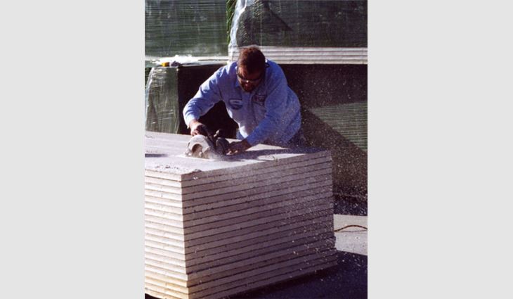 A roofing worker cuts polyisocyanurate insulation.