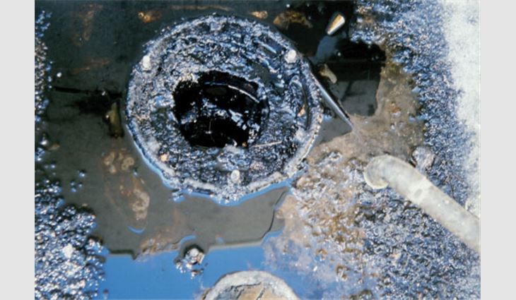 This photo shows a rooftop drain that distributes grease contaminants into the environment. 