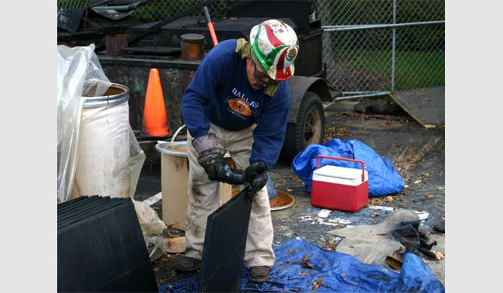 A worker pours charcoal granules into a plastic filter.