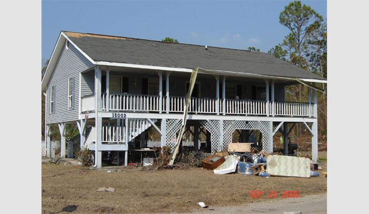 Located only 3 miles to 4 miles (5 km to 6 km) from St. Louis Bay, this house experienced water surge damage. It also experienced some of the highest winds because of its proximity to the coast where Katrina made landfall as a Category 3 hurricane. Only a small portion of the newer asphalt shingles were blown off along the leading edge.
