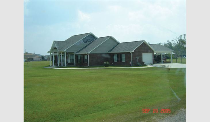 This house in Plantation Oaks subdivision, east of Picayune, Miss., is about 25 miles (40 km) north of the coast along Route 43. The newer laminated asphalt shingles fared well. The gable-end siding did not. The gutter along the west edge of the carport was damaged during the hurricane.
