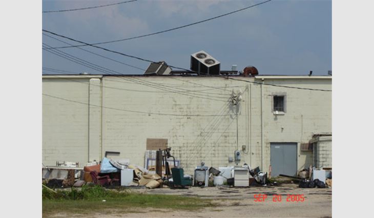 Photo 10. This building in the central business district of Picayune, Miss., is about 25 miles (40 km) north of the coast. The low-slope asphalt roof system appeared to fare well relative to the high winds. However, the heating, ventilating and air-conditioning units toppled during the storm, likely damaging the roof system. A 20-foot (6-m) portion of the edge metal/gutter system blew off.