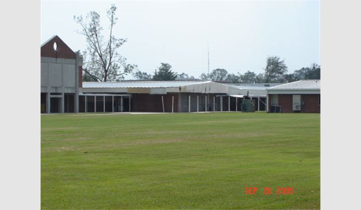 Photo 12. This structure is about 25 miles (40 km) north of the coast and north of the central business district of Picayune, Miss. The metal panel roof system fared well except for the gable end above the open air balcony/covered walkway, which is believed to have been pressurized or blown in directly.