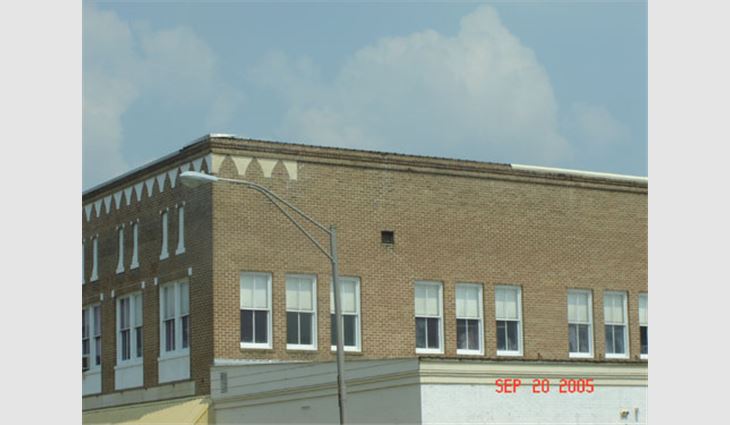 Photo 13. This structure in the central business district of Picayune, Miss., is about 25 miles (40 km) north of the coast. The metal coping was installed over the original coping caps without any face fasteners, clips or cleats. Portions of the coping blew off during the hurricane.