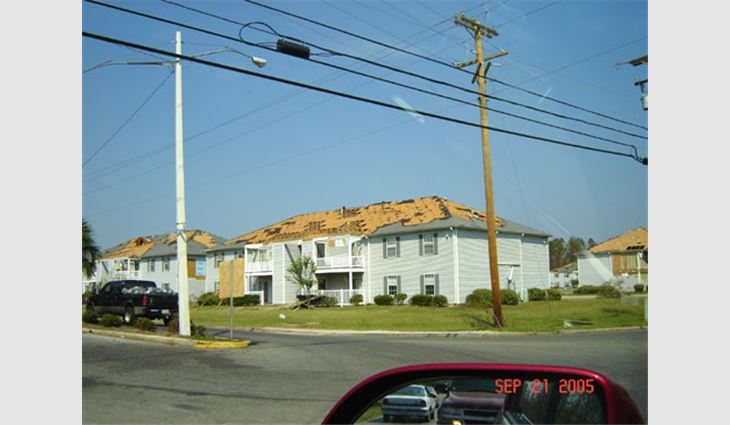 Photo 23. This entire complex of apartment buildings in Gulfport, Miss., received significant damage to its asphalt shingle roof systems. It appears that some of the roof deck is missing because the second-floor balconies were pressurized from the underside.