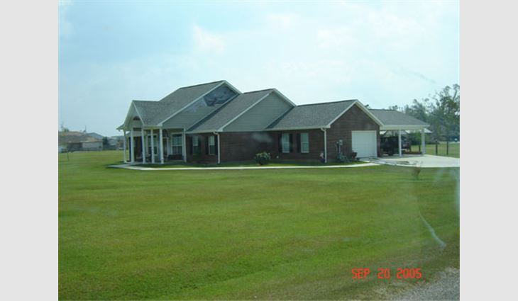 Photo 4. This house in Plantation Oaks subdivision east of Picayune, Miss., is about 25 miles (40 km) north of the coast along Route 43. The newer laminated asphalt shingles fared well. The gable-end siding did not. The gutter along the west edge of the carport was damaged during the hurricane.