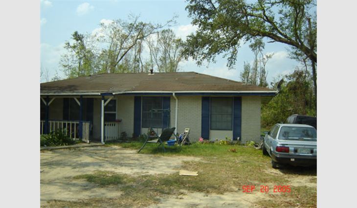 Photo 8. In the southwestern part of Picayune, Miss., this house is about 25 miles (40 km) north of the coast. The three-tab asphalt shingles were racked, and about 50 percent of the shingles blew off.