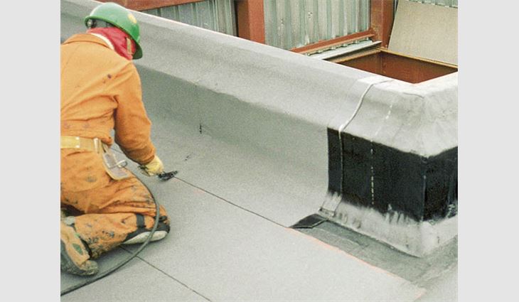 A Canadian roofing worker applies a modified bitumen membrane during winter.
