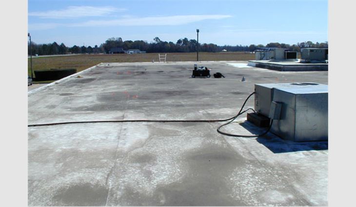 Photo 2: This photo shows the reality of a white roof surface membrane used in areas of heavy agricultural activity. The soil atop the membrane certainly has robbed the roof of its potential energy savings. Rather than trying to repeatedly clean the roof surface, using ballast would have been a better design choice in this situation.
