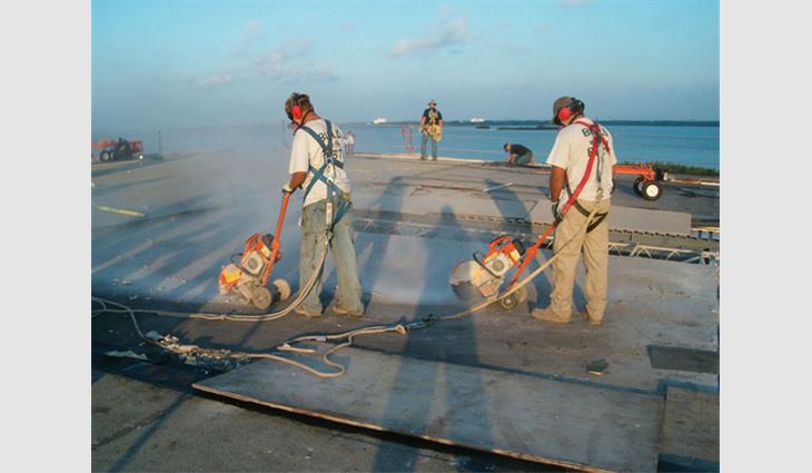 Roofing workers cut the existing 2-inch-thick gypsum deck. Two to four saws ran continuously during this process.
