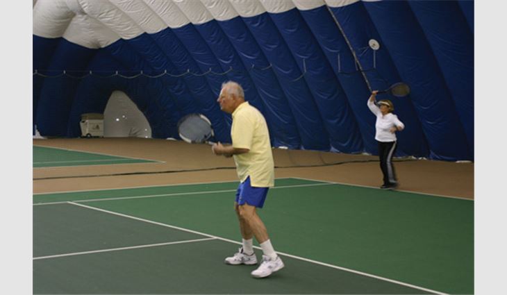 Barry Segal, president and chief executive officer of Bradco Supply Corp., Avenel, N.J., and Pam Zamrzla, of Western Pacific Roofing, Palmdale, Calif., play a game of tennis during the ROOFPAC tennis tournament.