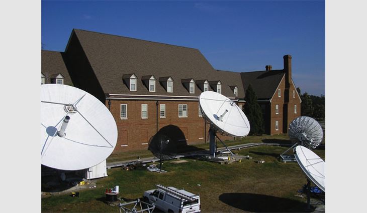 The company had to work around the building's loading dock; the roofing crew tears off the old cedar shakes on the main entrance of the CBN support center; special staging was required to work around large transmission satellites.