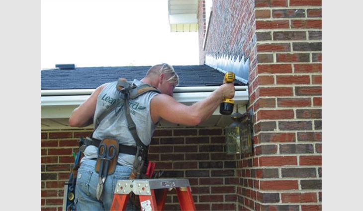 A LeafGuard by Beldon Enterprises employee installs a gutter protection system. 