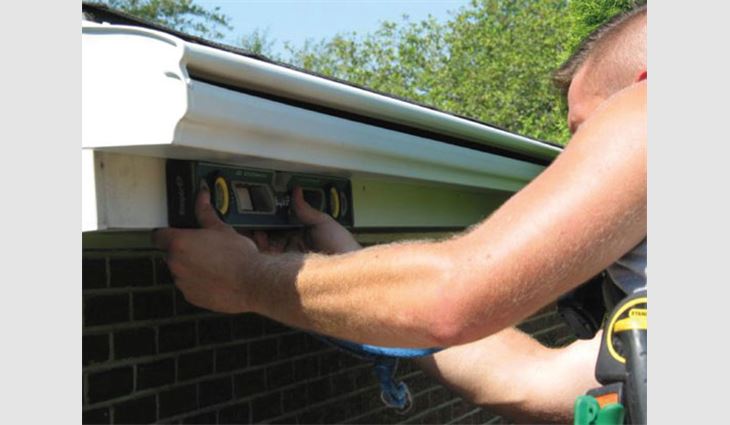 A LeafGuard by Beldon Enterprises employee installs a gutter protection system. 