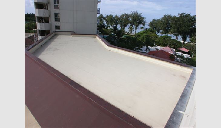 A tan acrylic coating on an EPDM roof system