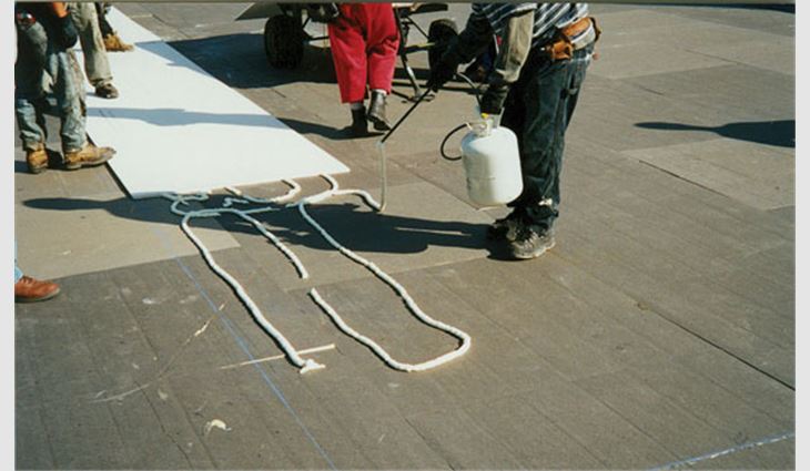 Photo 3: If wands are used to dispense adhesive, roofing workers must be careful not to space the rows too far apart.