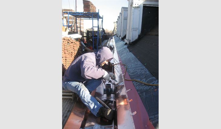 Wagner Roofing employee Randy Herald solders the built-in gutter