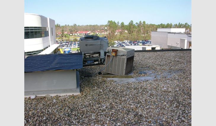 Photo 2: Water entered this building where the equipment blew off the curb. Note that an adjacent condenser shifted off its sleepers. Even in areas with low wind speeds, sleepers typically offer inadequate wind resistance. To resist ASCE 7 loads, equipment typically will need to be anchored to flashed curbs or equipment stands. 