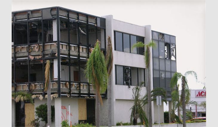Photo 5: A substantial number of windows in this building were broken by wind-borne debris. There was sufficient breakage to cause development of high internal pressure, which damaged the ceilings and ducts and exerted additional pressure on the roof assembly. A substantial amount of interior damage was also caused by entry of wind-driven rain. 