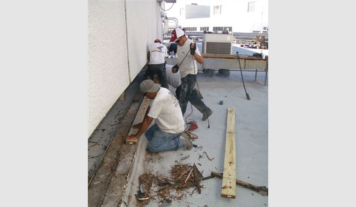 An Insulated Roofing Contractors crew replaces the roof system's existing expansion joints.