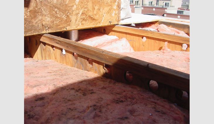 Photo 1: In this low-slope roof assembly, holes are provided in roof framing members in an attempt to provide cross-ventilation.