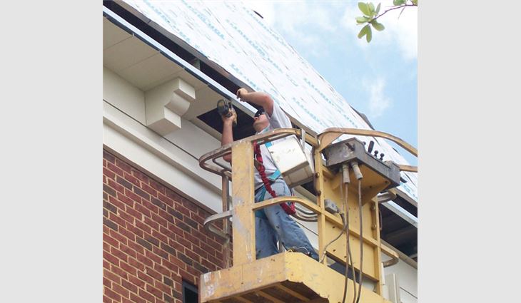 A Marty Robbins Roofing employee installs soffit and dentil mould