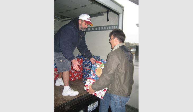 Don Katzenberger, owner of S&K Roofing, Siding and Windows, and Ray Smallwood, the company's operations manager, load a truck with donated items.