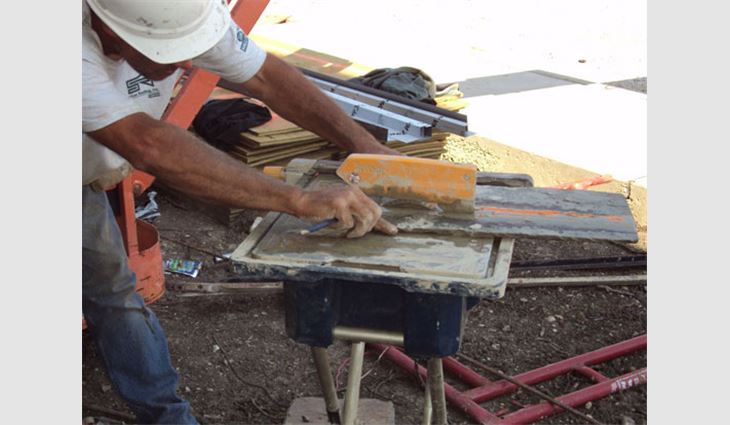 A Sullivan Roofing worker cuts a slate