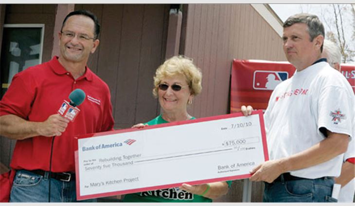 Allen Staff (left), senior vice president and regional executive for Bank of America, and NRCA Executive Vice President and Rebuilding Together's Chairman of the Board Bill Good present a $75,000 check to Gloria Suess of Mary's Kitchen, which was rehabilitated by Rebuilding Together, Bank of America and Major League Baseball. 