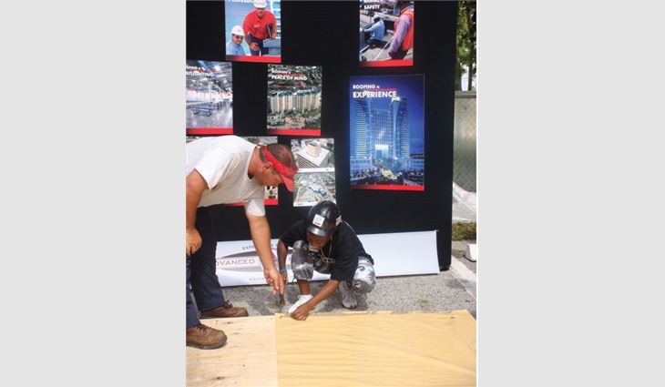 Baytosh teaches a participant how to nail a base sheet during the Boys & Girls Clubs of America's Construction Career Day.