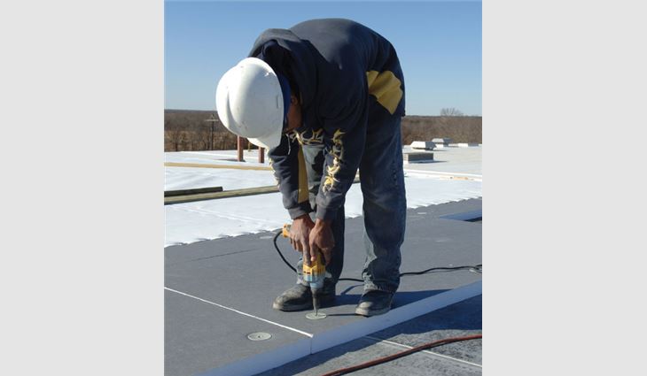 A worker installs EPS insulation panels.