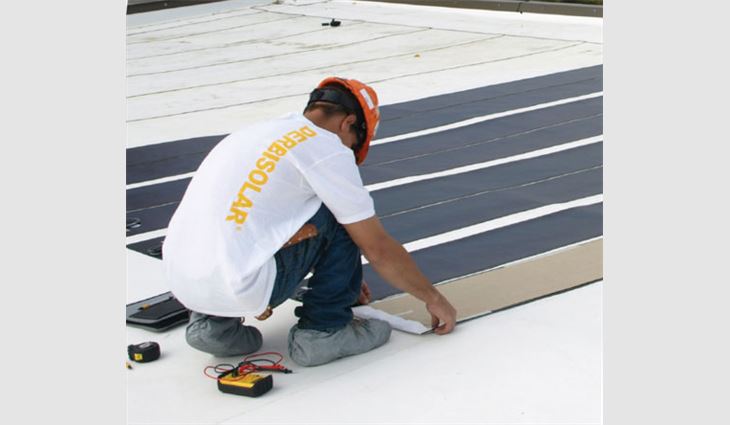 A Cornell Roofing & Sheet Metal employee installs solar panels on Bayer CropScience's roof system.