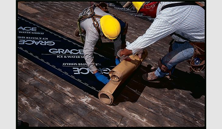 Step four of the back-roll underlayment installation method: Hold the release liner with one hand and pull the roll along the roof deck with the release liner, leaving the applied membrane behind.