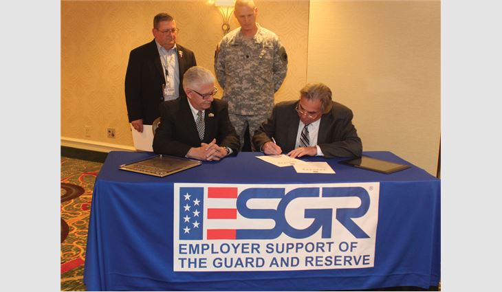 NRCA President Rich Nugent signs a Statement of Support for hiring members of the National Guard and Reserves.