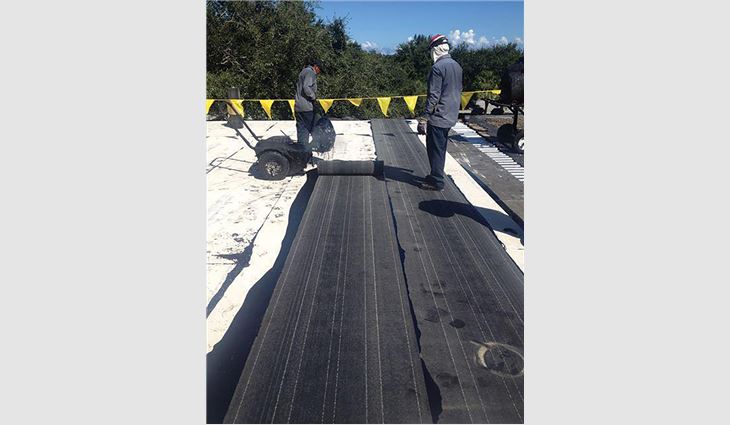 Workers build the new hybrid roof system.