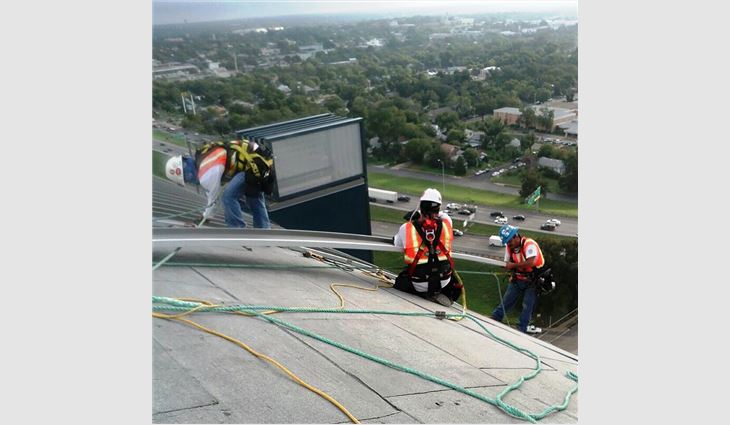 Workers "walked" each metal panel into place.