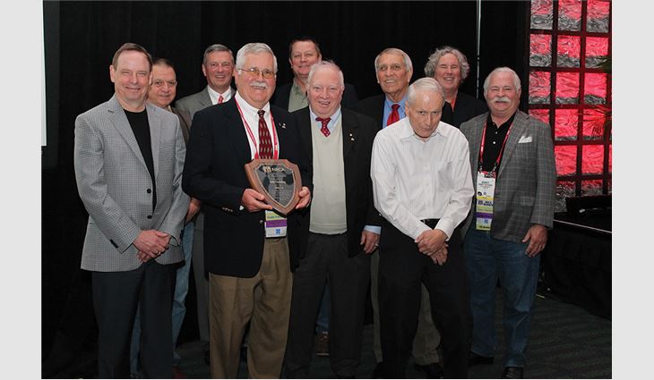 Previous winners of the J.A. Piper Award honor John Gooding with the 69th J.A. Piper Award, the roofing industry's highest honor. 
