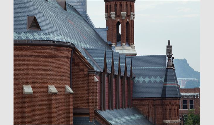 The church's contrast of red slate and polychromatic banding within the slate roof reflect the Gothic Revival era of the 1870s.