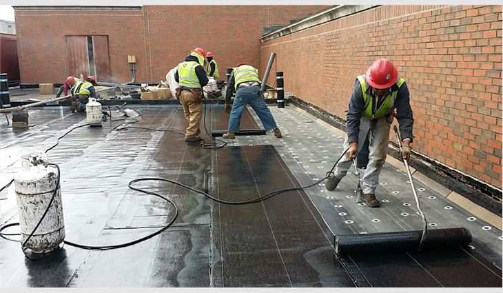 Workers torch new base and cap sheets.