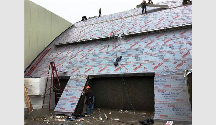 Workers install the hangar's new 44,000-square-foot roof system.