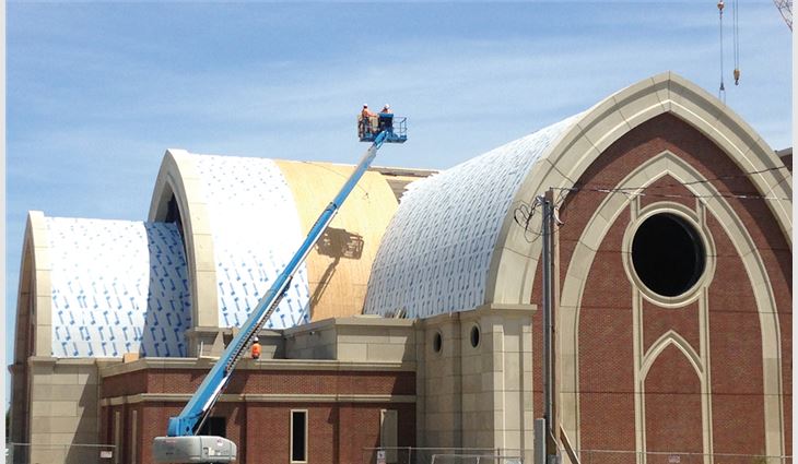 Workers installed new nail-base insulation and underlayment on the church's curved roof